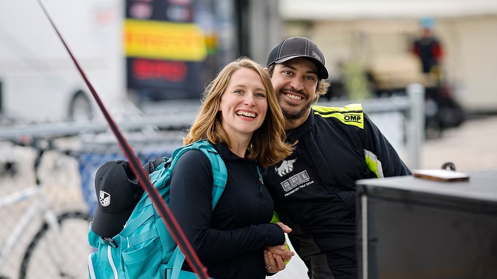 Dr. Ashley Witson and her husband smiling together trackside at a motorsports event